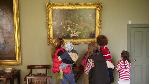 A family of visitors looking at a gold-framed painting at Ardress House
